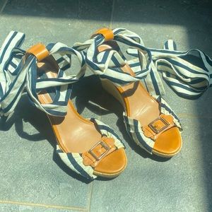 Navy and white espadrille sandals with brown leather details.